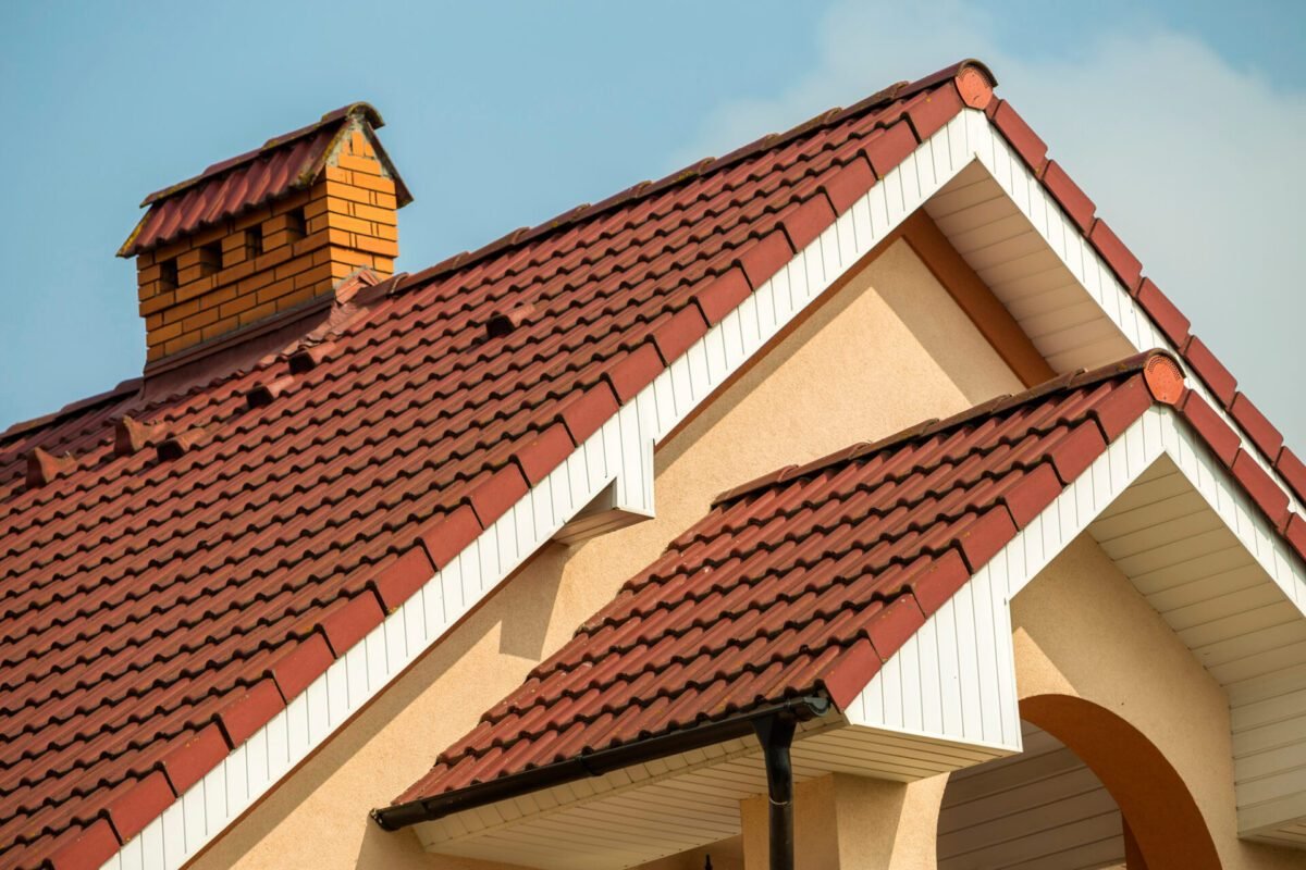 Red clay tile roof with a brick chimney on a stucco home