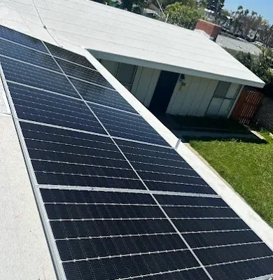 Solar panel array installed on the flat roof of a single-story home