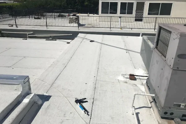 White coated flat commercial roof with rooftop HVAC units