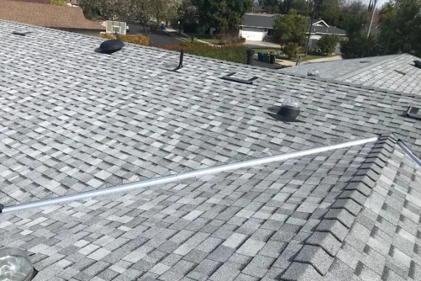 Grey asphalt shingle roof with vents after replacement