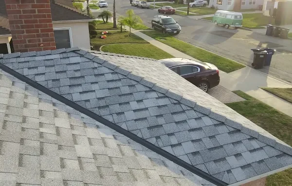 New dimensional shingle roof with a brick chimney above a street